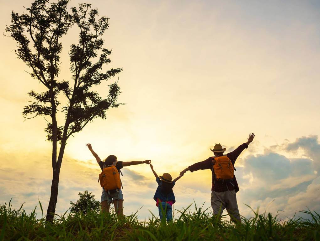 Family group of mum, child and dad enjoying the outdoors under a tree (cropped) » HCi