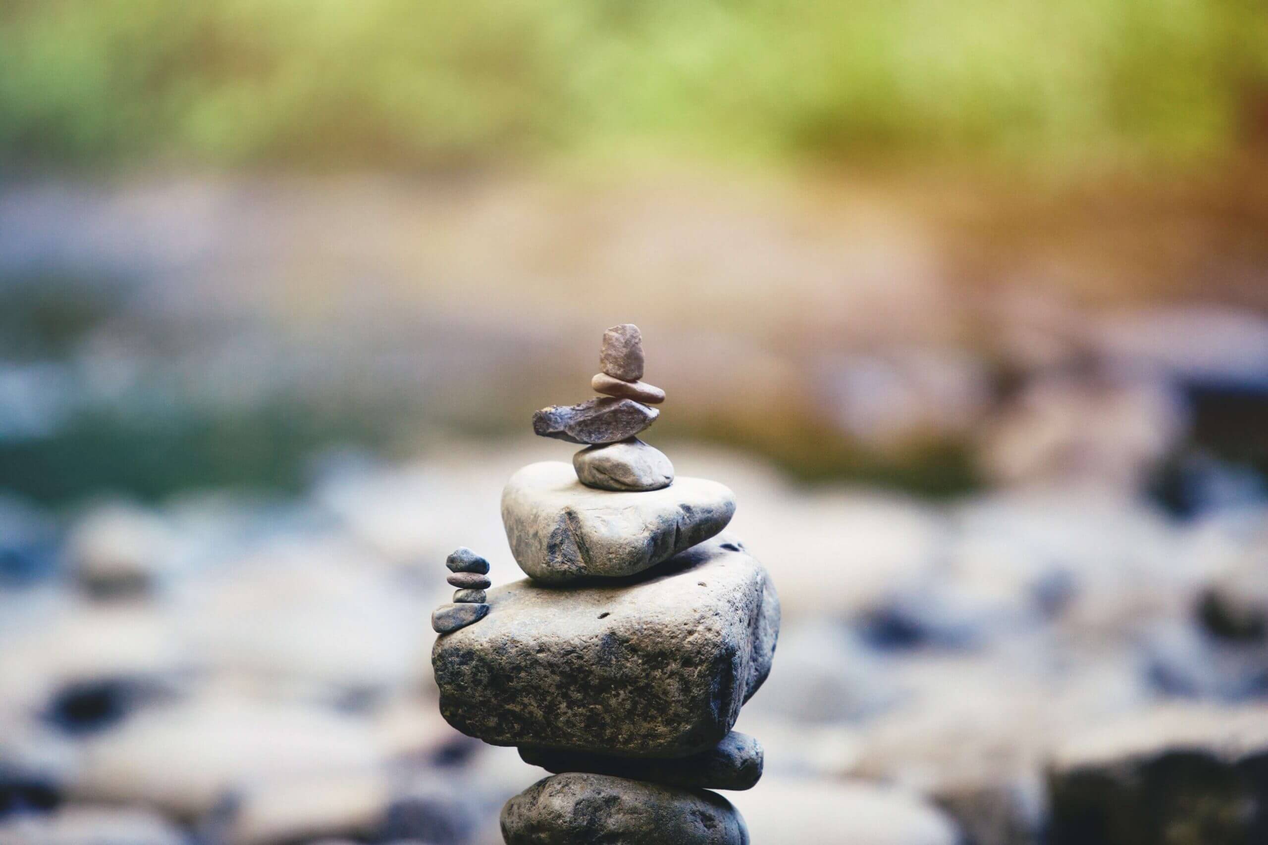 Beautifully balanced pile of stones in front of a creek