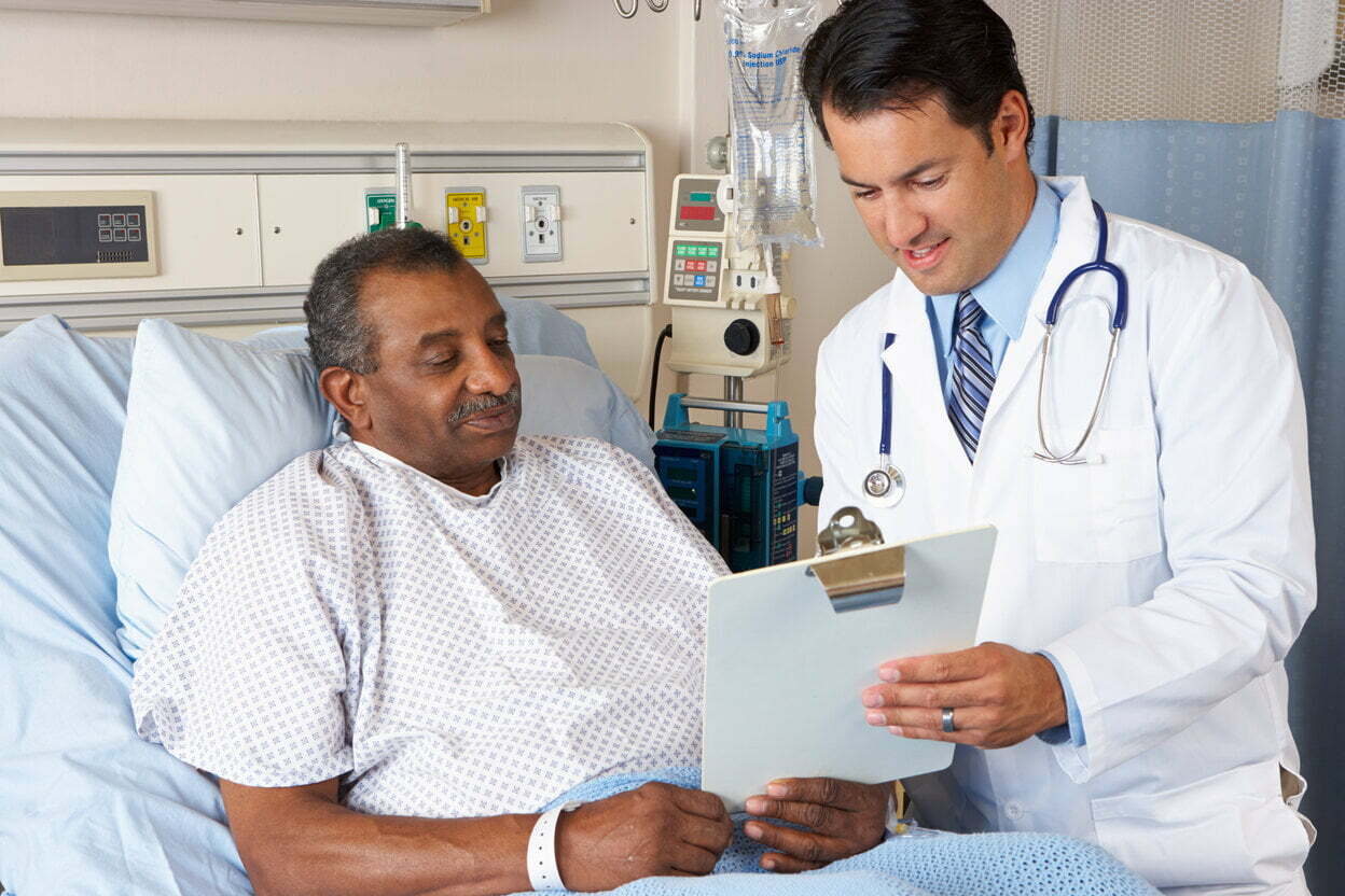 Doctor explaining consent form to a man in a hospital bed » HCi