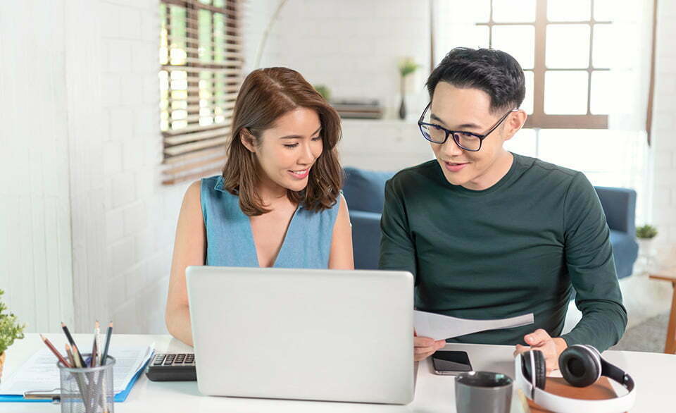Young Asian couple looking at a statement at their laptop » HCi
