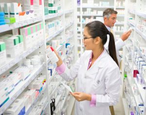 Two pharmacists selecting medicines off shelves, ahead of members' pharmacy claims